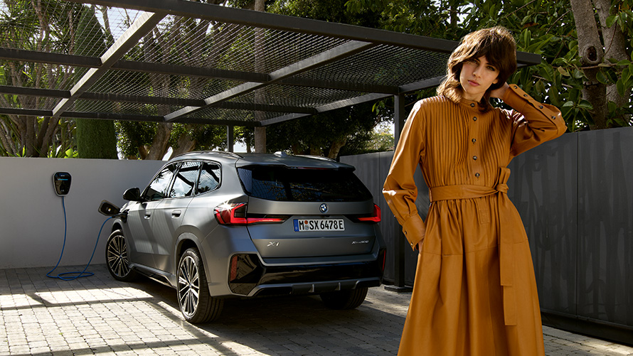 Plug-in hybridní BMW X1 2022 U11 Pohled zezadu při nabíjení s modelem Plug-in hybridní BMW X1 2022 U11 Pohled zezadu při nabíjení s modelem
