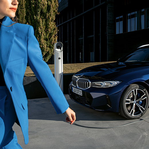 Nabíjení BMW žena chodící v popředí