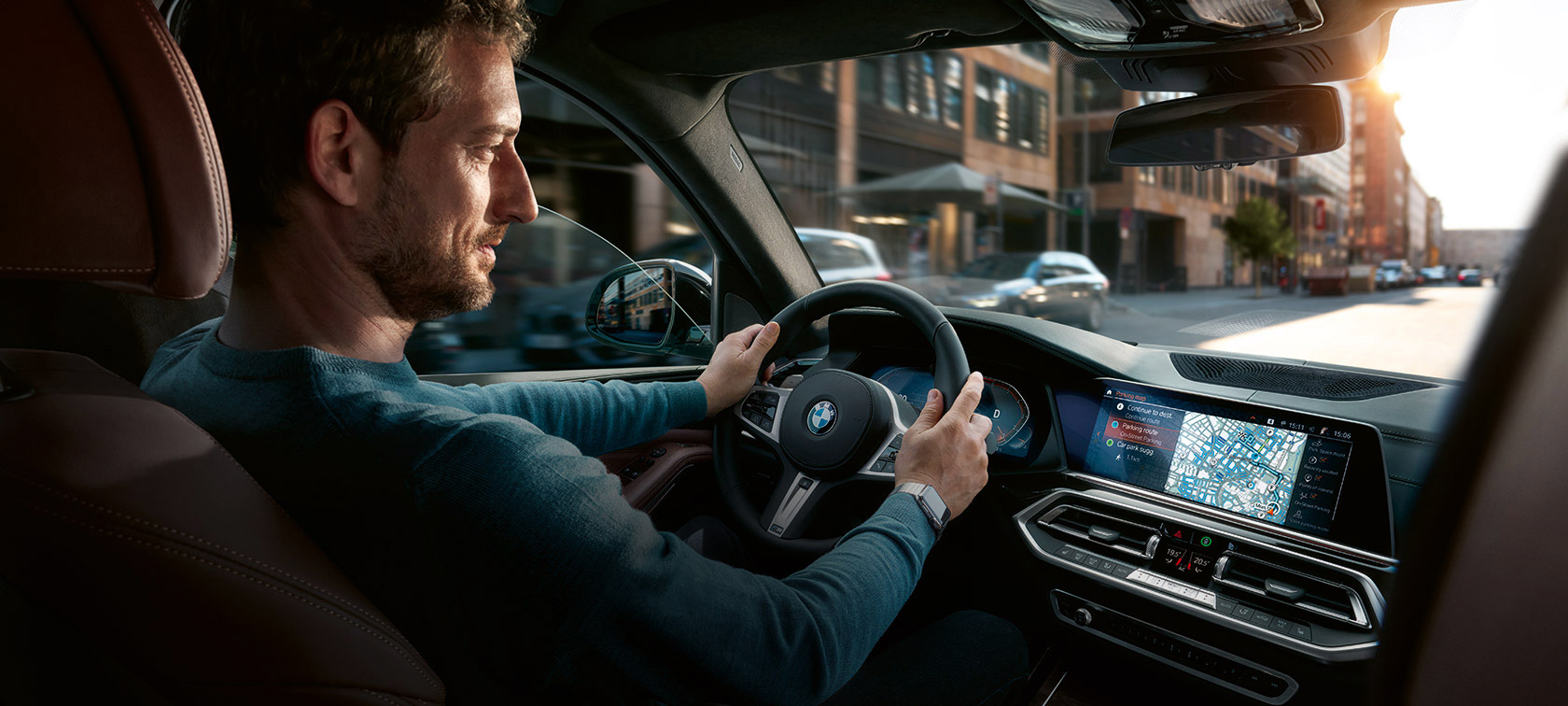 Navigace BMW Maps Muž jede s BMW a má na kontrolním displeji navigaci BMW Maps