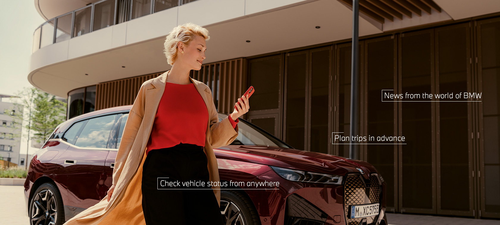 Žena před BMW iX používá aplikaci My BMW v chytrém telefonu Žena před BMW iX používá aplikaci My BMW v chytrém telefonu