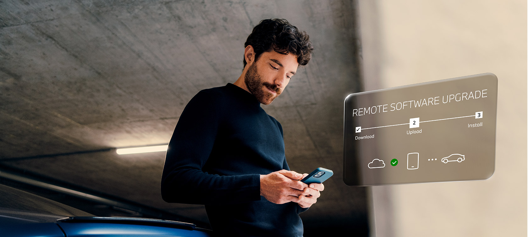 Muž před BMW se dívá do svého chytrého telefonu Remote Software Upgrade Muž před BMW se dívá do svého chytrého telefonu