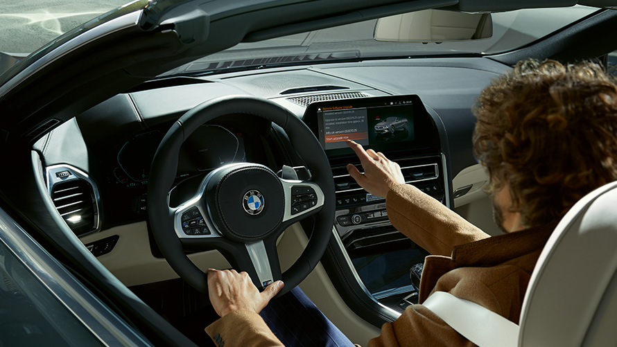 Aktualizace Remote Software Upgrade Remote Software Upgrade muž sedí v BMW a používá kontrolní displej