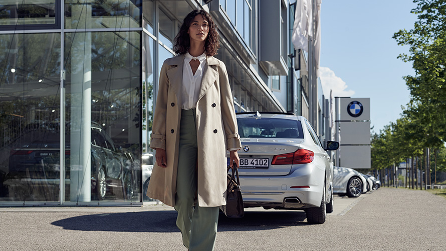 BMW Service Inclusive Žena před BMW dealerstvím
