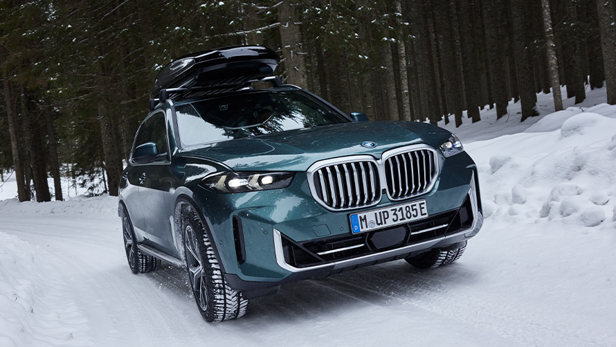 BMW Kompletní sada zimních kol na BMW X6 (G05 LCI) na zasněžené cestě v lese BMW Kompletní sada zimních kol na BMW X6 (G05 LCI) na zasněžené cestě v lese