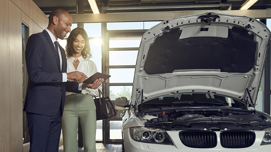 Kontrola a údržba Zákazník BMW Servisu a zaměstnanec BMW Servisu diskutují o kontrole a údržbě