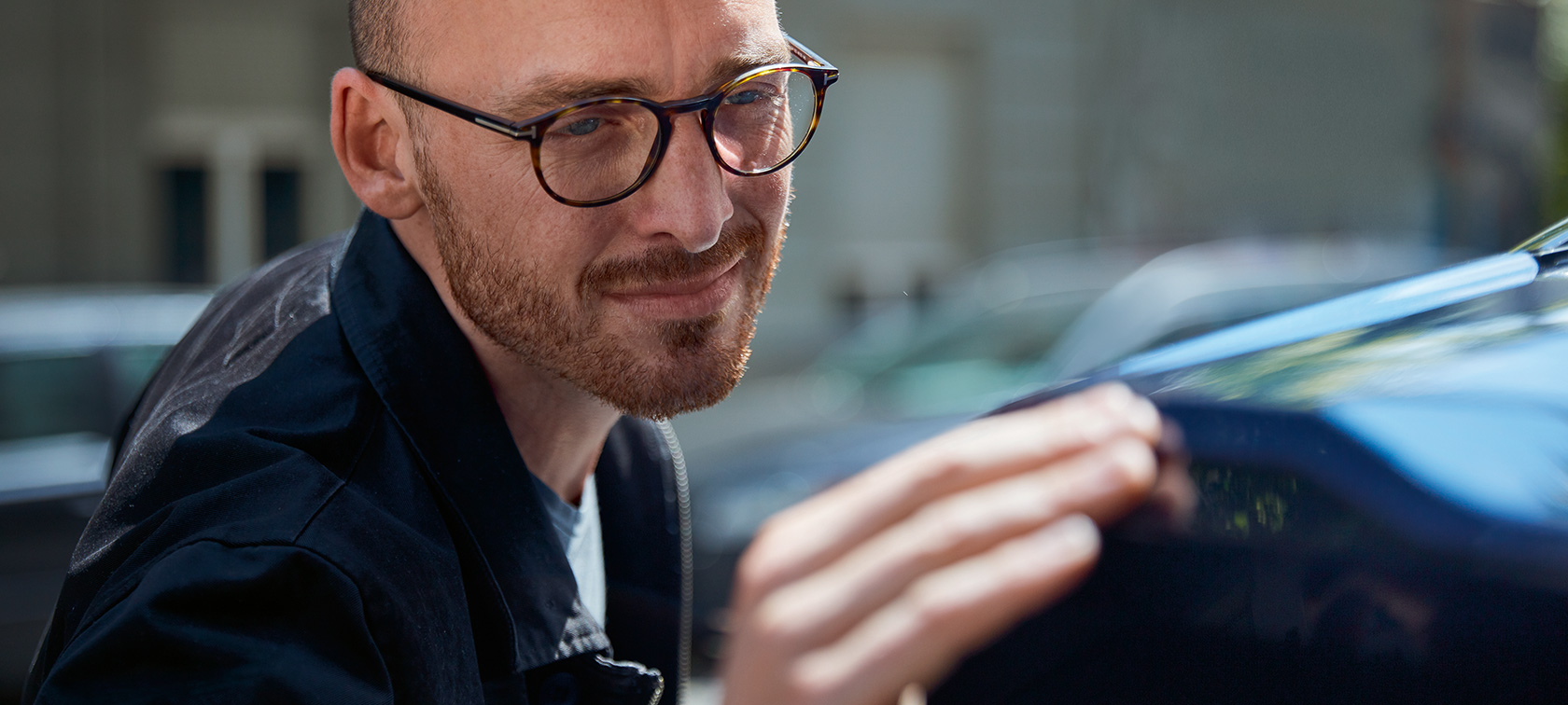 Muž se s citem dotýká svého BMW. Muž se s citem dotýká svého BMW.