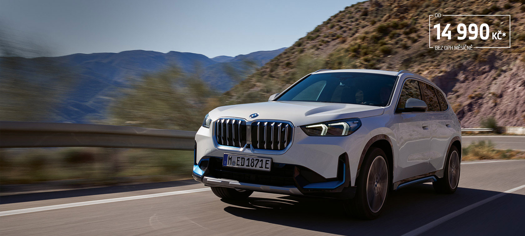 BMW iX1 U11 BEV 2022 metalický lak Mineral White tříčtvrteční pohled zepředu jízdní záběr na horských serpentinách