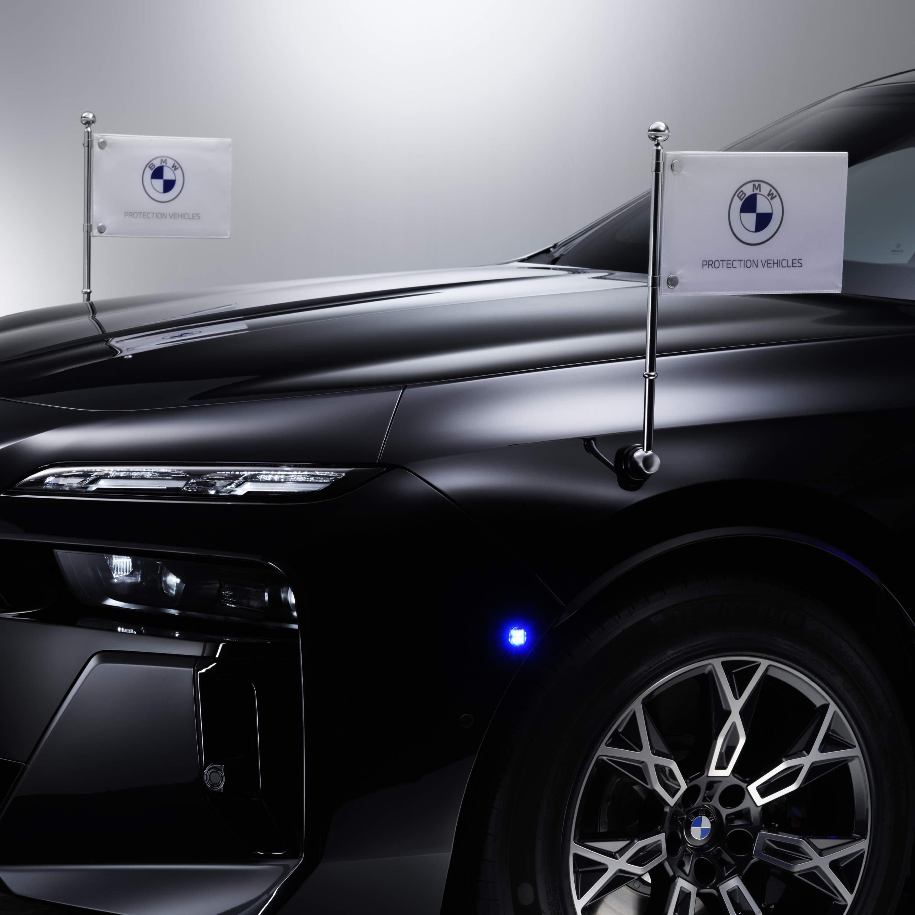 BMW s detailním záběrem dvou držáků vlajek vpředu
